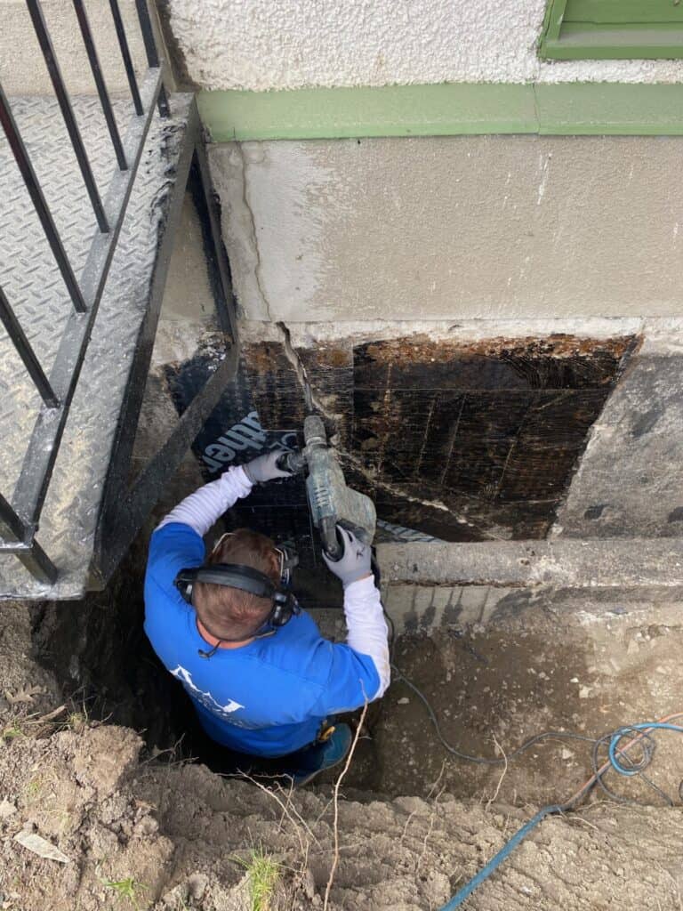 An Above Water technician is repairing a foundation crack on a concrete wall